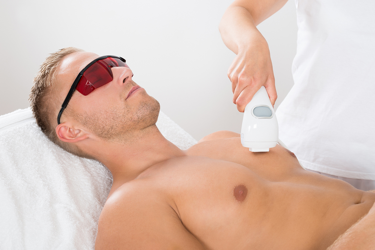 The man lying down with a laser hair removal device